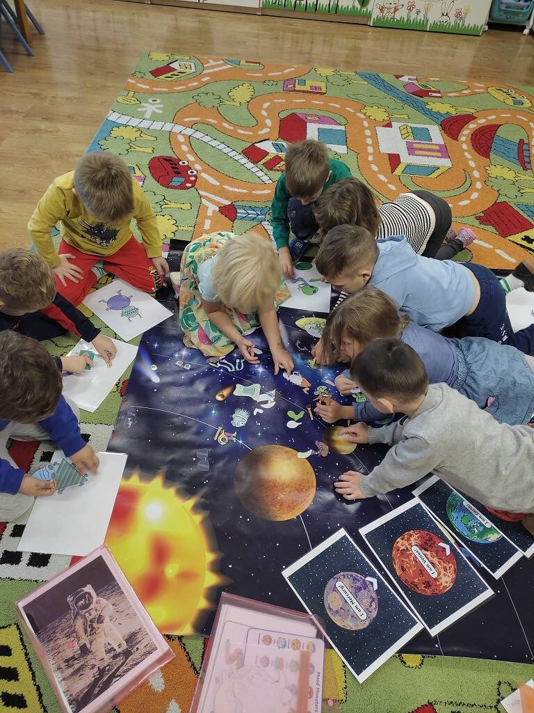 Dzieci uczące się angielskiego przez zabawę na kolorowym dywanie edukacyjnym