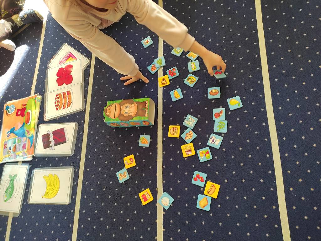 Dzieci uczące się angielskiego przez zabawę na kolorowym dywanie edukacyjnym