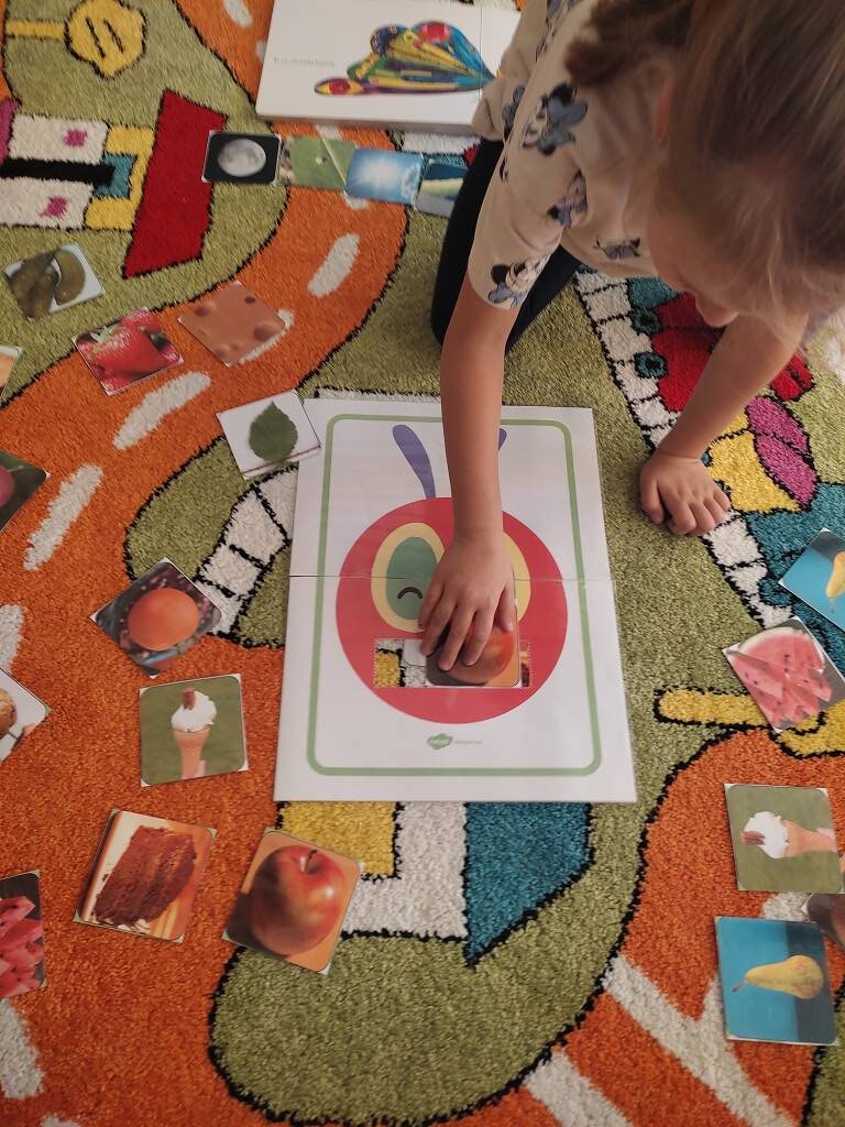 Dzieci uczące się angielskiego przez zabawę na kolorowym dywanie edukacyjnym